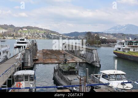 Quai flottant pour la réparation de navires et de bateaux de croisières touristiques sur le lac de Lucerne dans le port de la ville de Lucerne. Autour sont amarrés de petits bateaux à moteur. Banque D'Images