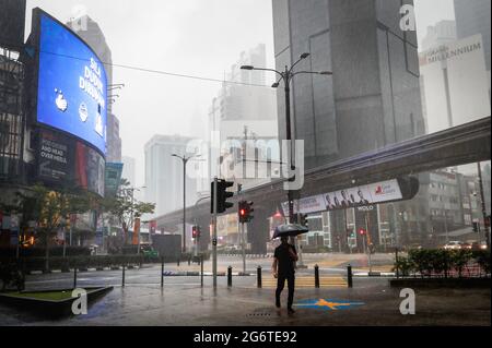 Kuala Lumpur, Malaisie. 08 juillet 2021. Un piéton à l'aide d'un parapluie, marche le long d'une rue déserte pendant une grosse descente dans le centre-ville. (Photo de Wong Fok Loy/SOPA Images/Sipa USA) Credit: SIPA USA/Alay Live News Banque D'Images