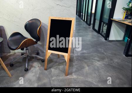 Panneau vide en bois avec chaise debout devant le bureau Banque D'Images