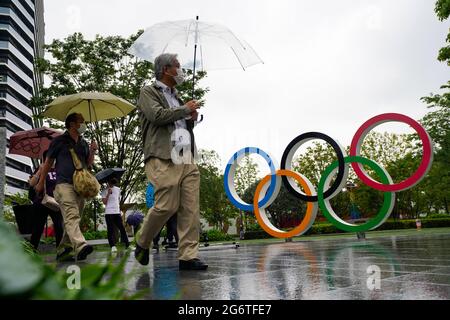 (210708) -- TOKYO, le 8 juillet 2021 (Xinhua) -- les gens marchent devant les anneaux olympiques près du nouveau stade national de Tokyo, au Japon, le 8 juillet 2021. Le gouvernement japonais a décidé jeudi de placer la capitale Tokyo sous le quatrième état d'urgence sur la COVID-19, couvrant la durée des Jeux Olympiques, dans un effort pour enrayer une récente vague d'infections. (Photo de Christopher Jue/Xinhua) Banque D'Images