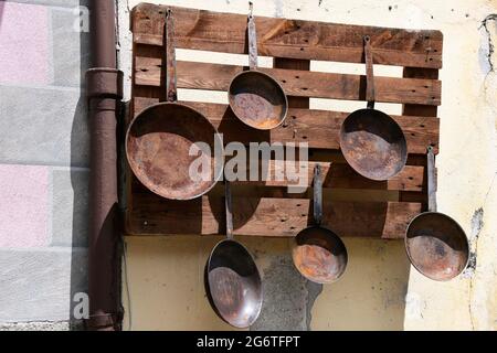 Alte gussiserne Pfannen an einer Hauswand im Bergdorf Montespluga, auf der SŸdseite des SplŸgenpasses, Provinz Sondrio, Italien Banque D'Images