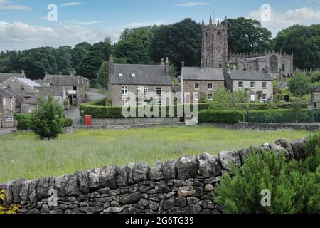 Vue sur le champ aux cottages en pierre et église paroissiale dans le village de Peak District - Hartington, Derbyshire, Angleterre, Royaume-Uni Banque D'Images