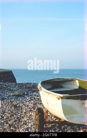 Petit bateau sur une plage de galets à Lyme Regis, Dorset, Angleterre, Royaume-Uni Banque D'Images
