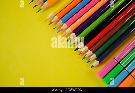 Les crayons de couleur sont alignés sur un fond jaune. Espace de copie Banque D'Images