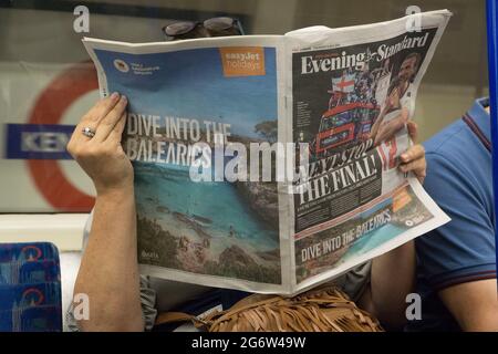 Londres, Royaume-Uni, 8 juillet 2021 : l'équipe de football des hommes d'Angleterre est jusqu'à la finale DE L'EURO 2020 et domine la première et la dernière page des journaux, comme lu par un couple dans le métro de Londres. Une publicité Easyjet pleine page espère attirer les clients qui pourraient profiter de l'assouplissement des règles de quarantaine pour les pays de la liste Amber à partir du 19 juillet. Anna Watson/Alay Live News Banque D'Images