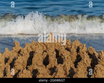 Maison construite château de sable avec des tours sur la rive sud de la plage de sable bleu mer Banque D'Images