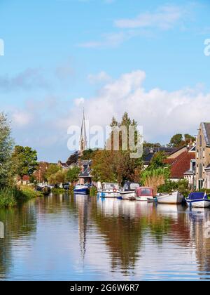 Canal de Wargaastervaart avec bateaux dans le village de Wergea, Leeuwarden, Frise, pays-Bas Banque D'Images