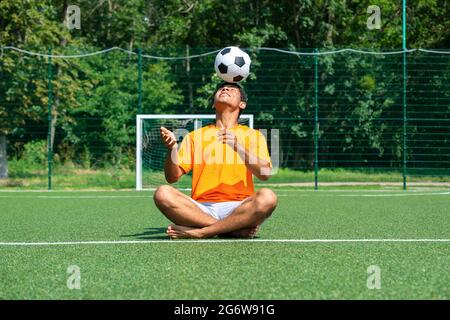 Le joueur brésilien de football s'entraîne et améliore le contrôle du ballon de football sur le terrain de sport Banque D'Images