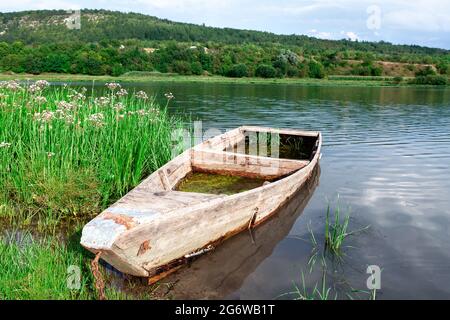 Bateau de pêcheur en bois coulé . Ancienne barque en bois . Nature pittoresque de la rivière Banque D'Images