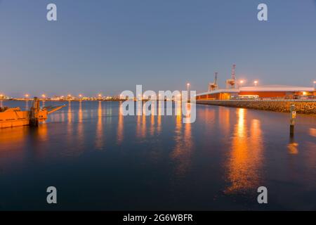 Image d'effet Tauranga Harbour, la barge jaune, l'installation de quai à conteneurs et les quais à travers le port en image de soirée de longue exposition et les linghts re Banque D'Images