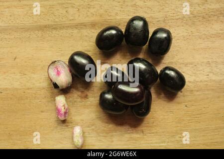 Fruits de prune de Java ou de syzygium sur une surface en bois isolée, vue de dessus, fruit de baies bleues, nouvelle image Banque D'Images