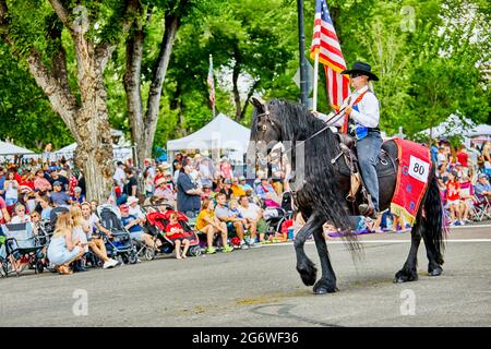 Prescott, Arizona, États-Unis - 3 juillet 2021 : cavalier équestre portant un drapeau américain à cheval dans le défilé du 4 juillet Banque D'Images