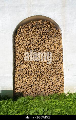 Une pile de bois de chauffage de bouleau sec dans le mur du monastère de Spaso-Yakovlevsky dans la ville de Rostov, région de Yaroslavl, Russie. Banque D'Images