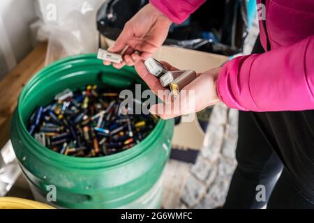 Les piles sont mises au rebut dans le centre de recyclage, mains de femme Banque D'Images