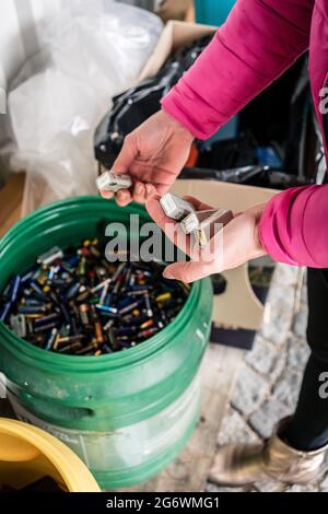 Les piles sont mises au rebut dans le centre de recyclage, mains de femme Banque D'Images