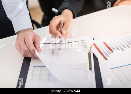 Homme et femme d'affaires l'analyse graphique à barres de statistiques et rapports financiers au bureau au bureau Banque D'Images