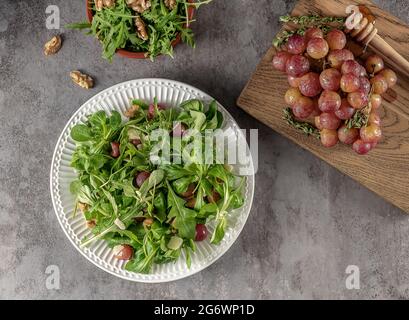 Salade délicieuse à base de raisins grillés caramélisés, d'arugula poivrée, de noix grillées et de pecorino. Banque D'Images