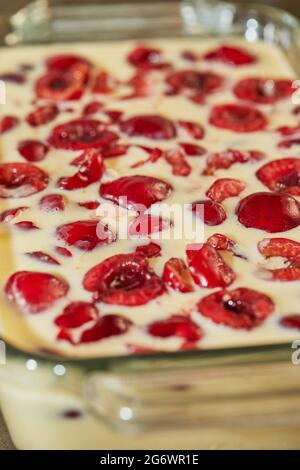 Pâte prête à l'emploi avec cerises dans le moule à tarte aux cerises, clafoutis. Recette étape par étape Banque D'Images