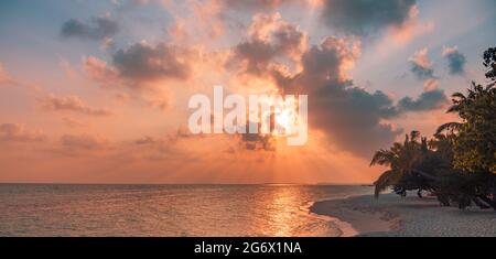 Coucher de soleil sur la plage. Paradis paysage plage. Paradis tropical, sable blanc, plage, palmiers et eau claire sous les rayons du soleil avec un été idyllique Banque D'Images