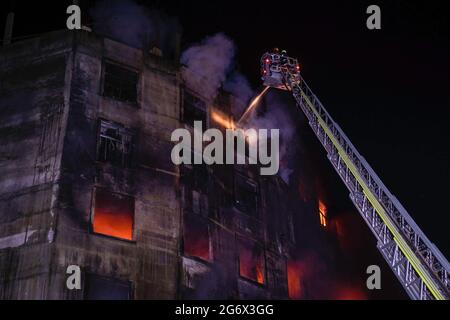 Les pompiers tentent d'éteindre le feu à l'intérieur du bâtiment après qu'un incendie a éclaté dans une usine nommée Hashem Foods Ltd à Rupganj, dans le district de Narayanganj, à la périphérie de Dhaka. Au moins trois personnes ont été tuées, 20 autres blessées et beaucoup sont craints piégés après un incendie massif qui a fait rage dans une usine, la cause de l'incendie qui a commencé au rez-de-chaussée d'un bâtiment de plusieurs étages de l'usine n'est pas encore connue. Banque D'Images