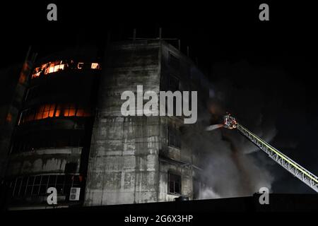 Dhaka, Bangladesh. 09e juillet 2021. Les pompiers tentent d'éteindre le feu à l'intérieur du bâtiment après qu'un incendie a éclaté dans une usine nommée Hashem Foods Ltd à Rupganj, dans le district de Narayanganj, à la périphérie de Dhaka. Au moins trois personnes ont été tuées, 20 autres blessées et beaucoup sont craints piégés après un incendie massif qui a fait rage dans une usine, la cause de l'incendie qui a commencé au rez-de-chaussée d'un bâtiment de plusieurs étages de l'usine n'est pas encore connue. (Photo de Piyas Biswas/SOPA Images/Sipa USA) crédit: SIPA USA/Alay Live News Banque D'Images