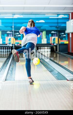Vue arrière d'une jeune femme bowling Banque D'Images