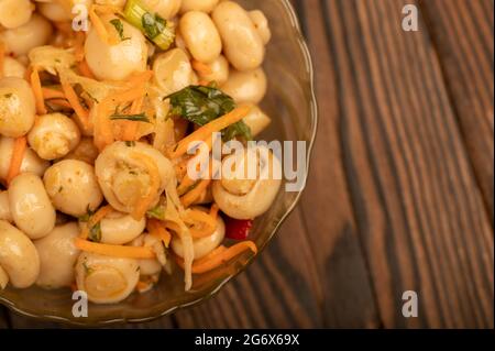 Champignons salés dans un plat en verre sur une table en bois. Gros plan mise au point sélective Banque D'Images