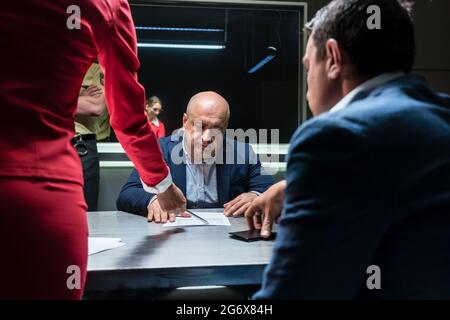 Défendeur d'âge moyen ou le témoin conseillé par l'avocat de signer une déclaration officielle devant le procureur, au cours d'une enquête criminelle dans Banque D'Images