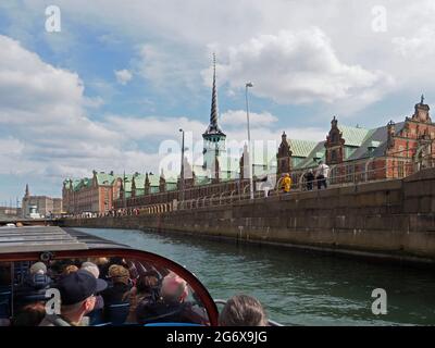 Une visite en bateau de Copenhague montrant les touristes sur un bateau d'excursion en observant la Bourse, le palais de Christiansborg et la flèche de Dragons Banque D'Images