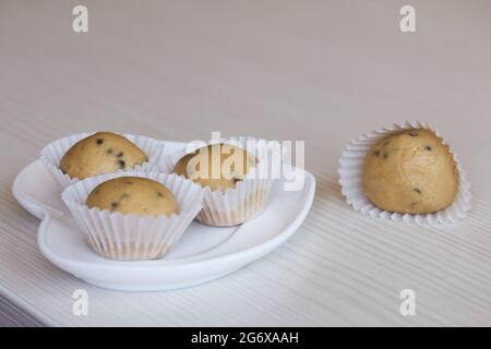Bonbons faits maison à base de farine de noix de coco, de beurre d'arachide et de chocolat. Ils se trouvent dans des tartelettes en papier. Banque D'Images