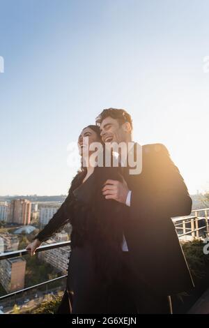 homme et femme riant en se tenant sur la terrasse Banque D'Images