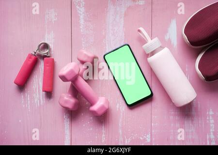 Téléphone intelligent avec équipement de sport sur parquet. Banque D'Images