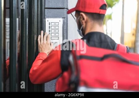 Homme pilote qui fournit des repas à la maison des clients tout en portant le visage Masque pendant l'épidémie de virus corona - concept de la livraison de nourriture Banque D'Images