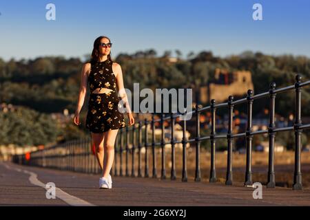 Photo : Natasha Jenkins fait une promenade au lever du soleil sur la promenade Mumbles, près de Swansea, pays de Galles, Royaume-Uni. Dimanche 13 juin 2021 objet: Températures élevées et s Banque D'Images