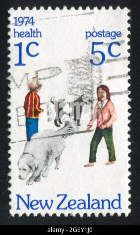 NOUVELLE-ZÉLANDE - VERS 1974: Timbre imprimé par la Nouvelle-Zélande, montre des enfants avec des chiens, vers 1974 Banque D'Images