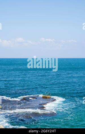 Poignées et échelle installées sur un rocher naturel en mer à Beyrouth, Liban Banque D'Images