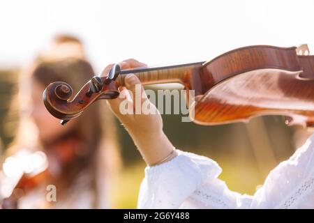 Accent sélectif sur le violon d'une jeune fille jouant à l'extérieur pendant le festival d'été Banque D'Images