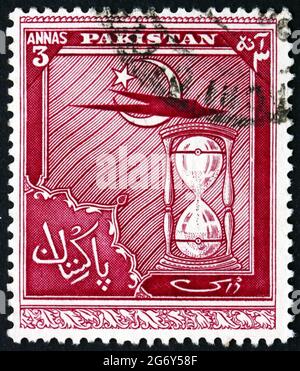 PAKISTAN - VERS 1951 : un timbre imprimé au Pakistan montre Star and Crescent, plane and Hour Glass, quatrième anniversaire de l'indépendance, vers 1951 Banque D'Images