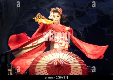 La femme danse avec un ventilateur et un parapluie, avec des manches fluides. Performance japonaise traditionnelle danse de renard rouge. Le renard Kino Kitsune est un personnage de Japanes Banque D'Images