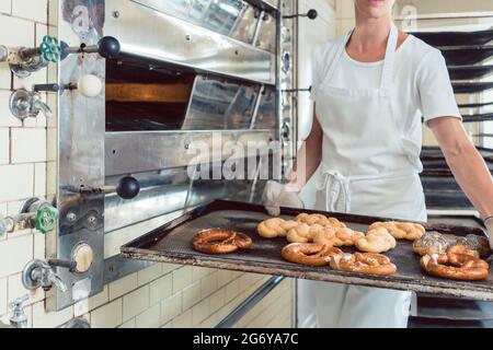 Baker est la présentation du pain frais sur le bac dans sa boulangerie Banque D'Images