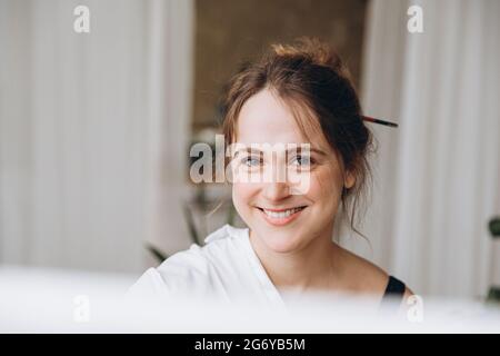 Artiste souriante assise près d'un chevalet Banque D'Images