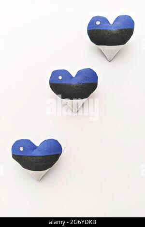 Trois coeurs faits main dans drapeau estonien couleurs broche sur fond blanc. Célébration de la journée de l'indépendance de l'Estonie Banque D'Images
