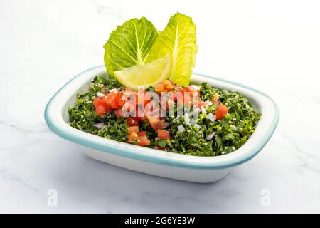 Salade arabe traditionnelle tabbouleh isolée sur fond de marbre Banque D'Images