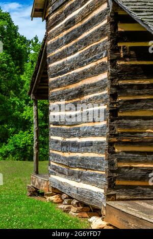 Cabane en rondins avec encoches en queue d'aronde et cliquetis. Les pierres empilées sont utilisées pour une base de fondation créant la zone de destruction nécessaire pour la maison. Robert Scruggs Banque D'Images