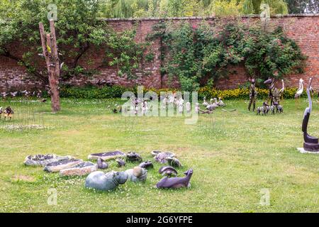 Petits oiseaux et sculptures fantaisistes d'animaux exposés au hasard dans un parc. Banque D'Images