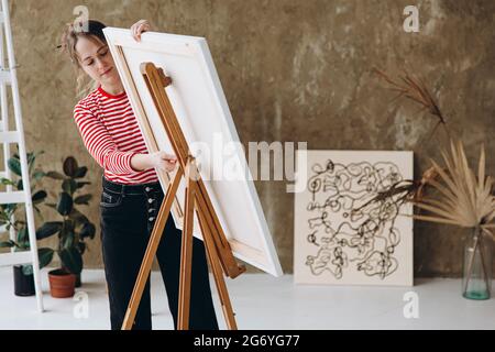 Jolie femme ajuster chevalet pour la peinture en studio Banque D'Images