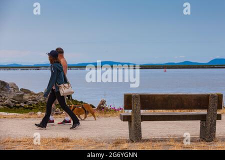 Couple marchant leur chien le long du front de mer de Garry Park à Steveston Colombie-Britannique Canada Banque D'Images