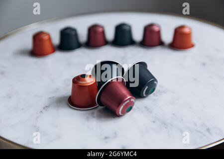 Capsules de café colorées sur une table blanche Banque D'Images