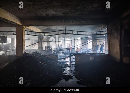 Narayanganj, Bangladesh. 09e juillet 2021. Les pompiers inspectent l'usine de Hashem Foods Ltd après qu'un incendie a éclaté à Rupganj, dans le district de Narayanganj, à la périphérie de Dhaka. Au moins 52 personnes ont été tuées, 25 autres blessées et beaucoup sont craints piégés après un incendie massif qui a fait rage dans une usine, la cause de l'incendie qui a commencé au rez-de-chaussée d'un bâtiment de plusieurs étages de l'usine n'est pas encore connue. (Photo de Zabed Hasnain Chowdhury/SOPA Images/Sipa USA) crédit: SIPA USA/Alay Live News Banque D'Images