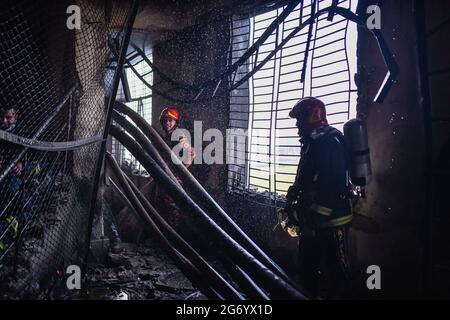 Narayanganj, Bangladesh. 09e juillet 2021. Les pompiers inspectent l'usine de Hashem Foods Ltd après qu'un incendie a éclaté à Rupganj, dans le district de Narayanganj, à la périphérie de Dhaka. Au moins 52 personnes ont été tuées, 25 autres blessées et beaucoup sont craints piégés après un incendie massif qui a fait rage dans une usine, la cause de l'incendie qui a commencé au rez-de-chaussée d'un bâtiment de plusieurs étages de l'usine n'est pas encore connue. (Photo de Zabed Hasnain Chowdhury/SOPA Images/Sipa USA) crédit: SIPA USA/Alay Live News Banque D'Images